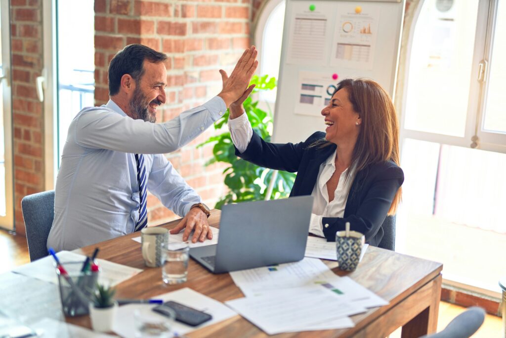 Zwei Personen im Büro geben einander High Five